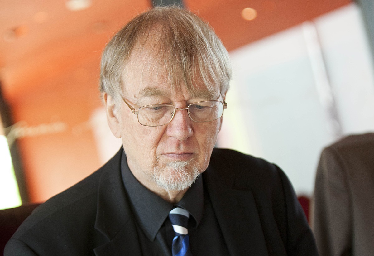 Grauhaariger Mann mit freundlichem Gesicht und Brille