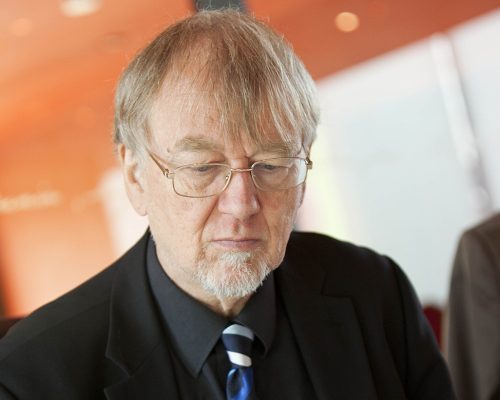 Grauhaariger Mann mit freundlichem Gesicht und Brille