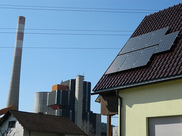 Photovoltaik auf einem Schindeldach, Fabrik im Hintergrund