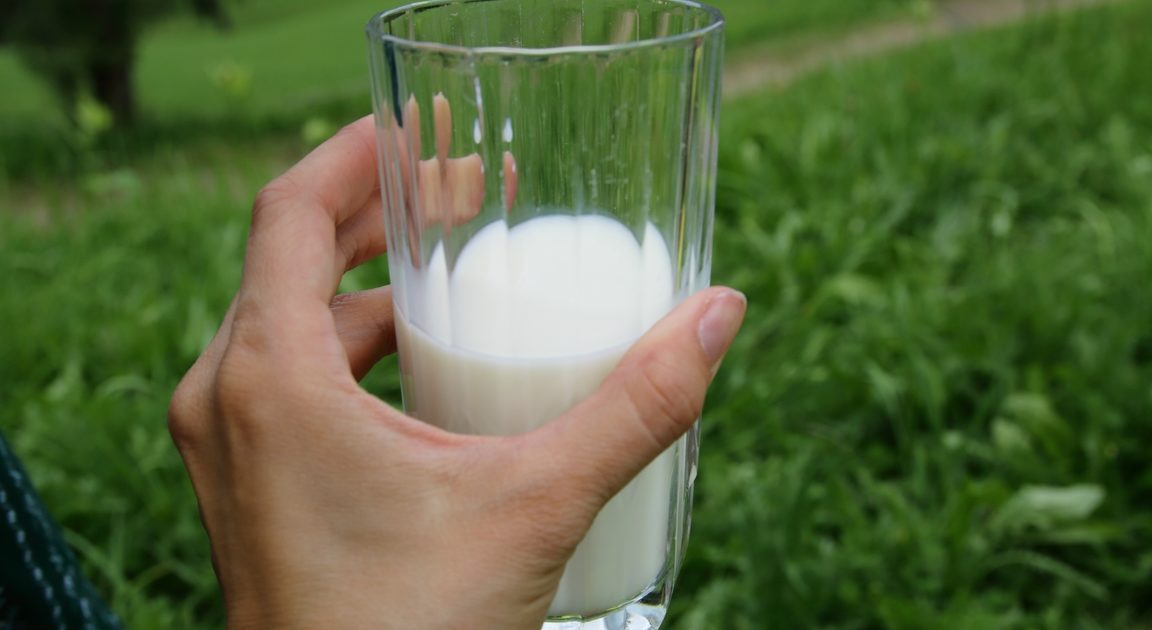 Frauenhand mit Glas Milch