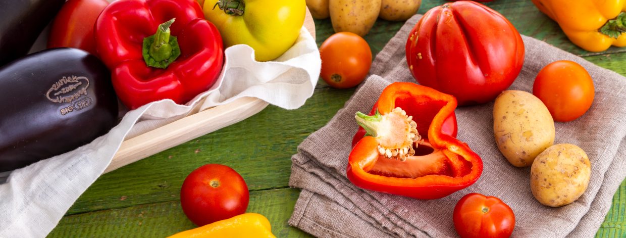 Buntes Gemüse auf grünem Tisch, Melanzani, Karotte, Erdäpfel etc.