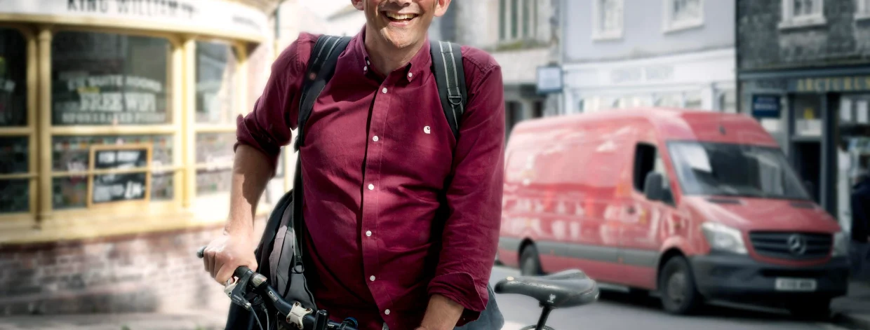 Freundlicher Mann mit rotem Hemd stützt sich auf Rad